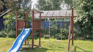 A playground with a slide, swings, and a wooden climbing structure.