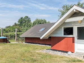 A red and white building with a sloped roof, a window, and a door. - 5 Star Holiday Home in Dannemare (Dannemare)