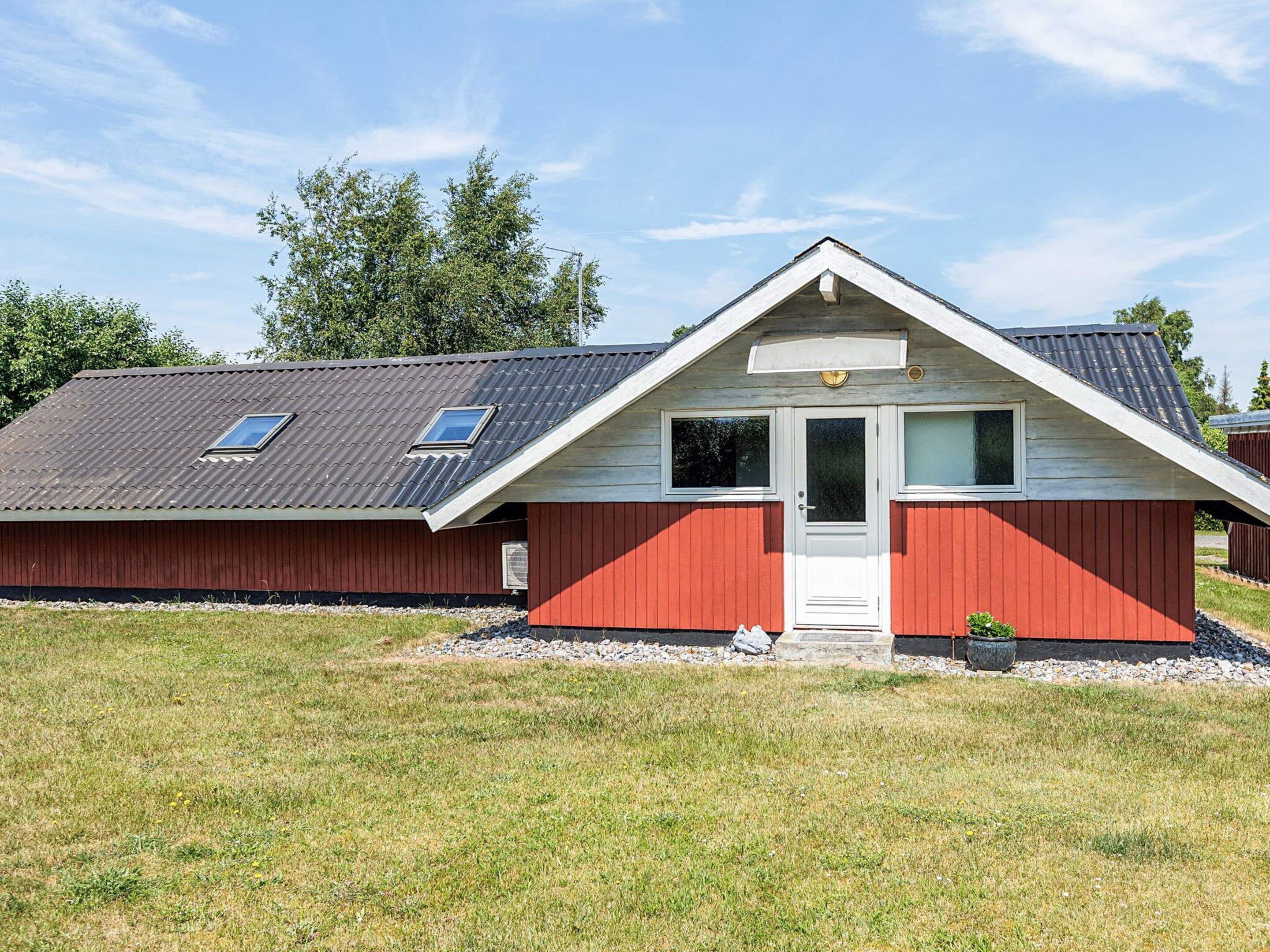 A single-story building with a gabled roof, a front door, and two windows.