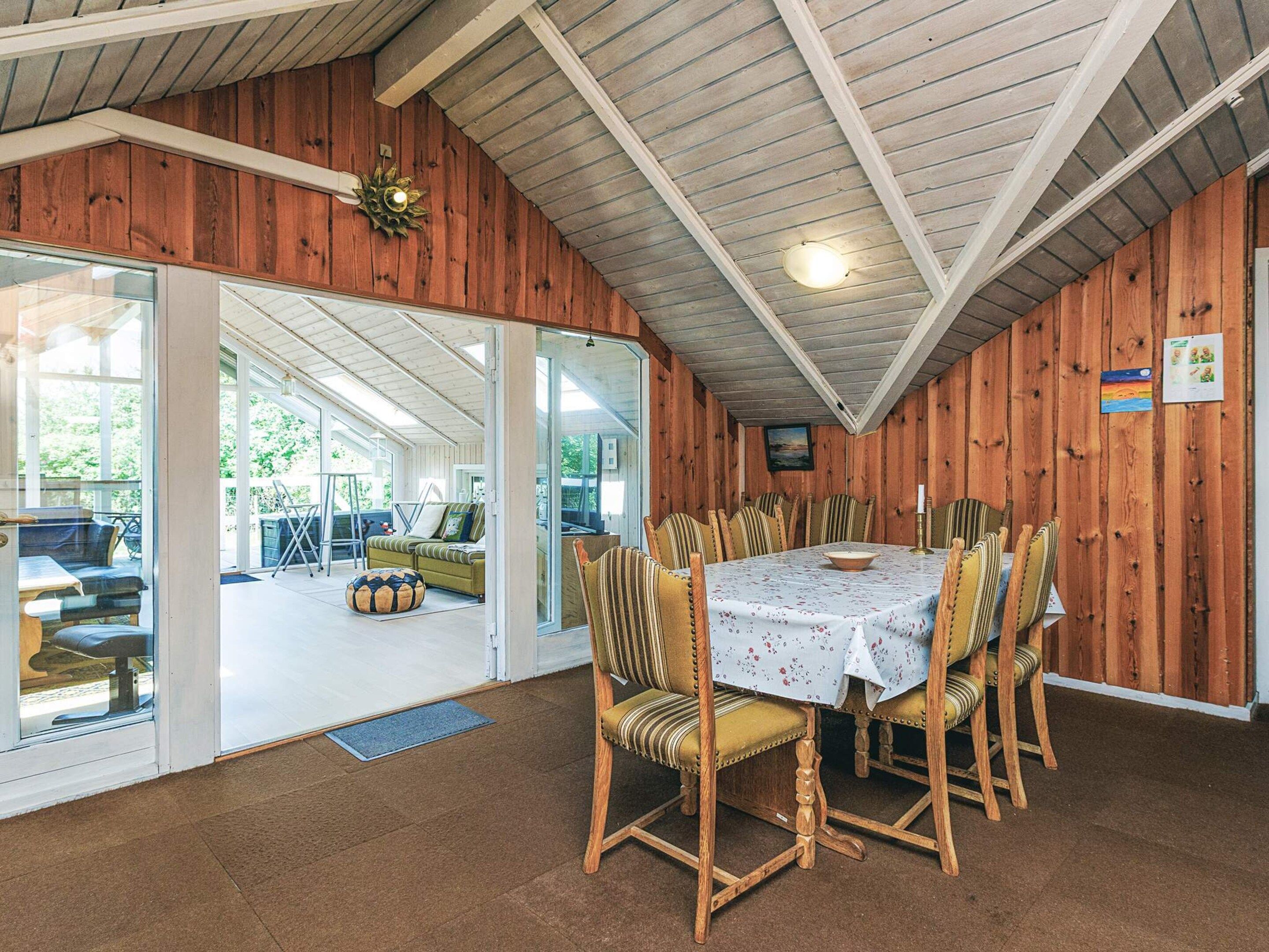 A dining area with a table set for six, surrounded by six chairs with striped upholstery.