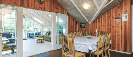 A dining area with a table set for six, surrounded by six chairs with striped upholstery.