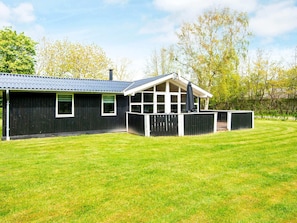 A black metal building with a large window and a covered patio area. - 8 Person Holiday Home in Hemmet (Hemmet)