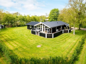 A modern house with a large deck, surrounded by a well-maintained lawn. - 8 Person Holiday Home in Hemmet (Hemmet)