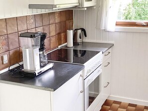 Eine Küche mit Kaffeemaschine, Wasserkocher und Herd.