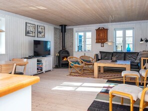 A cozy living room with a fireplace, a television, and comfortable seating. - 4 Star Holiday Home in Ringkobing (Ringkobing)