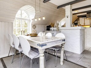 A dining area with a white table, chairs, and a chandelier. - Unique Pet Friendly Holiday Home in Jerup near Sea (Jerup)