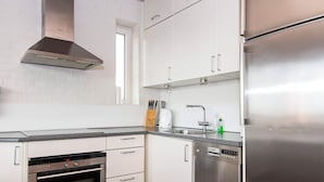 A modern kitchen with white cabinets, stainless steel appliances, and a window above the sink. - Beachfront Bungalow Bliss - By Traum Ferienwohnungen (Henne)