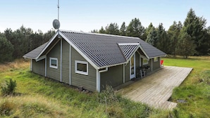 A single-story house with a sloped roof, a satellite dish, and a small deck. - 7 Person Holiday Home in Blavand (Blavand)