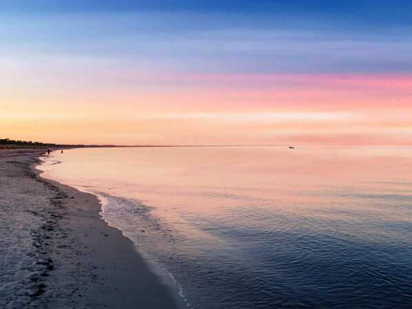 A beach with a calm sea and a clear sky.