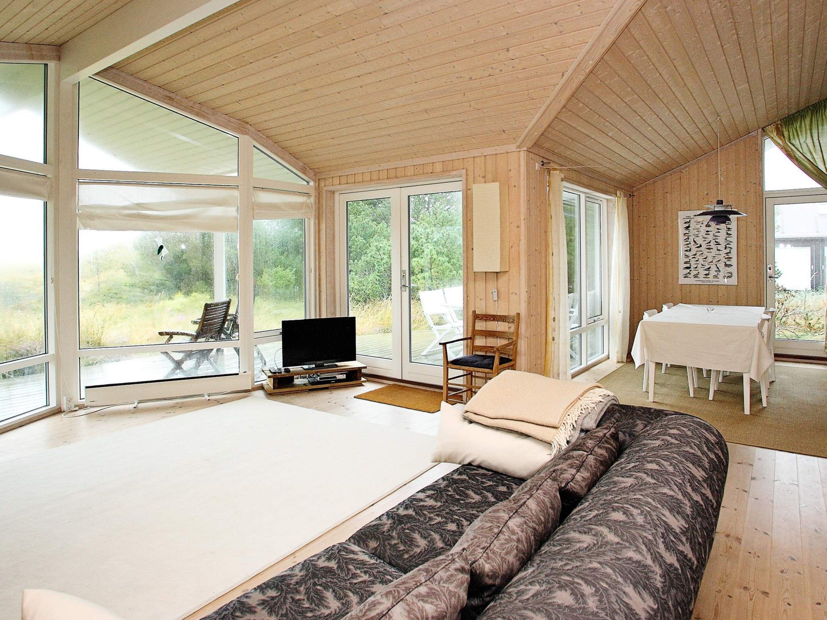 A spacious room with a large bed, a television, and a dining area with a table and chairs.
