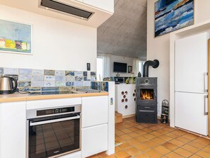 A modern kitchen with a built-in stove, a dishwasher, and a refrigerator.