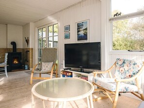 A cozy living room with a fireplace, a television, and comfortable seating. - Serene Holiday Home in Bindslev near Beach (Bindslev)
