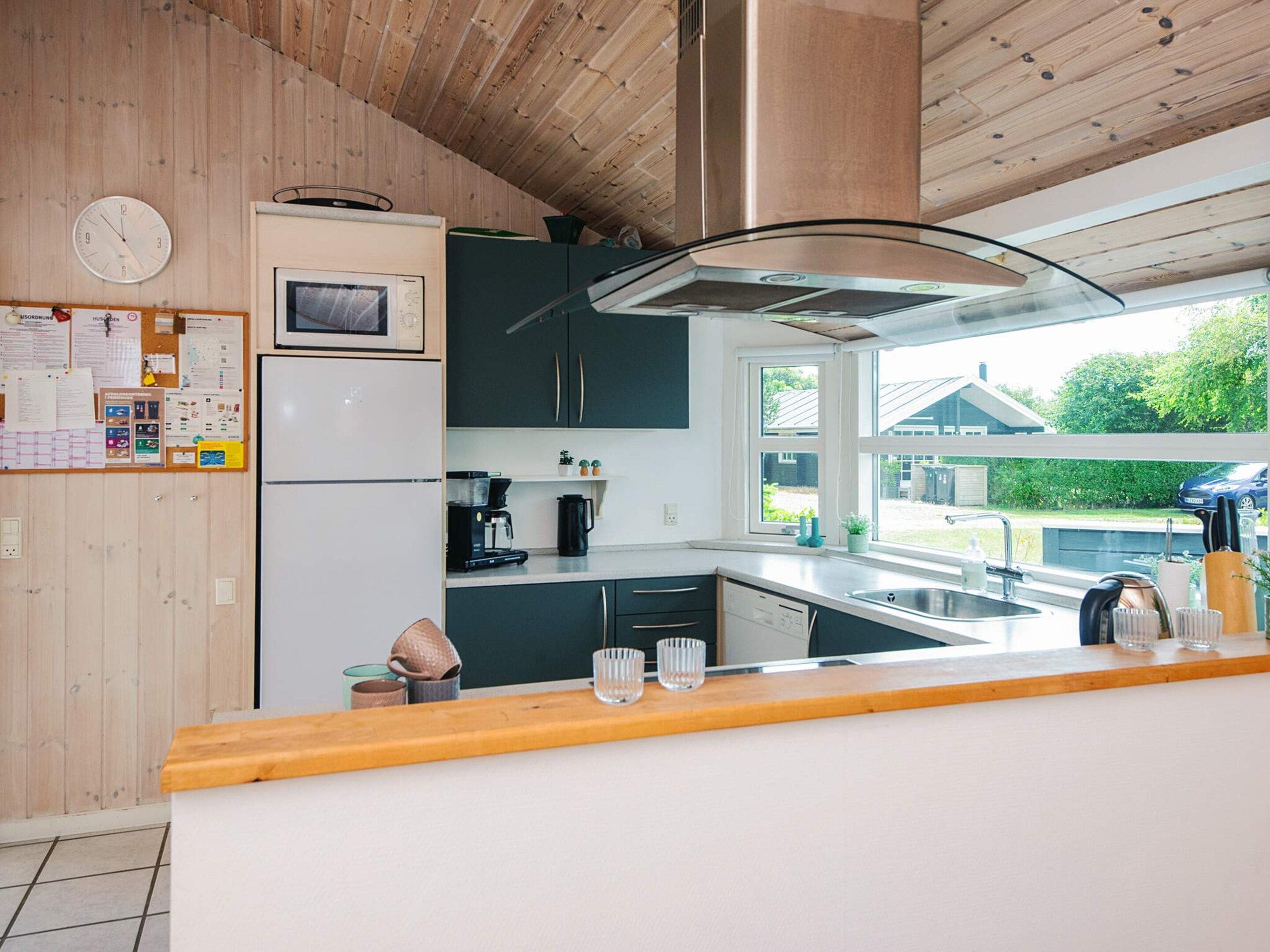 A modern kitchen with a built-in microwave, coffee maker, and a large window offering a view of the outside.