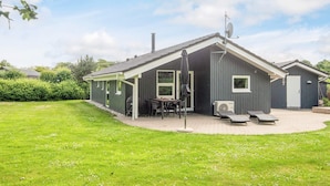 Yhden kerroksen talo, jossa on katettu patio, grillauspaikka ja satelliittiantenni.