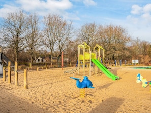 A playground with a slide, climbing structures, and a blue and yellow toy. - 4 Star Holiday Home in Oksbol (Oksbol)