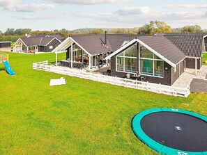 A residential area with multiple houses, a playground, and a trampoline.