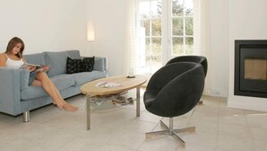Ein modernes Wohnzimmer mit einer Couch, einem runden Couchtisch und einem schwarzen Sessel.