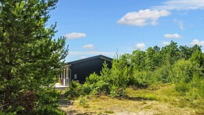 A rustic cabin surrounded by dense greenery and a clear sky. - 5 Person Holiday Home in Glesborg-by Traum (Glesborg)
