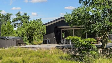 A modern building with a covered outdoor seating area and a small table.