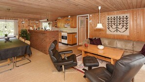 A cozy cabin interior with a dining area, kitchen, and seating space.