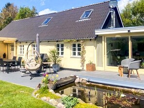 A house with a large patio, a swimming pool, and a garden. - 5 Person Holiday Home in Vig (Vig)