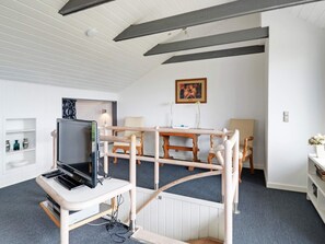 A room with a bunk bed, a television, a desk, and a chair.