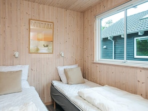 A room with wooden walls, two beds, a window, and a wall-mounted sign. - 5 Star Holiday Home in Henne (Henne)