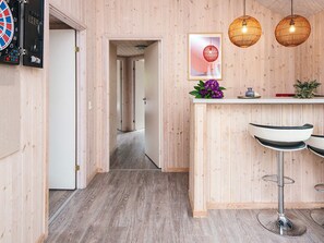 A wooden-paneled room with a dartboard, a framed picture, and two hanging light fixtures. - 5 Star Holiday Home in Henne (Henne)