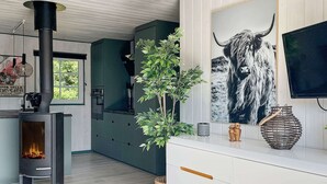 Uma cozinha moderna com uma lareira a lenha, uma janela grande e uma planta decorativa.
