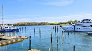A marina with boats docked, calm water, and a dock extending into the water.