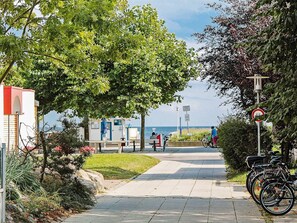 A pathway leading to a beach with a bench, a bicycle, and a sign indicating no bicycles. - Holiday Home in Grossenbrode (Grossenbrode)