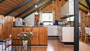 Een compacte keuken met houten wanden, een centraal keukenblok en moderne apparaten.