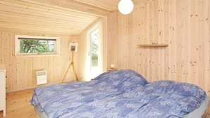 Une chambre à coucher avec un lit, une fenêtre, un lampadaire et une étagère.