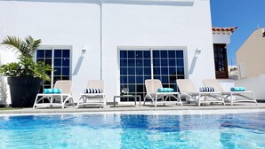 A poolside area with lounge chairs and a potted plant. - Bright and airy spacious three bedroom Holiday Home with private pool (La Caleta)
