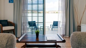 A room with a view of a balcony, a dining table with chairs, a potted plant, and a wall-mounted artwork. - Bright and airy spacious three bedroom Holiday Home with private pool (La Caleta)