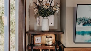 A wooden shelf with a white vase of flowers, a clock, and a jar of popcorn. - Condo - Pets OK - Fireplace, Sleeps 4! (Deming)