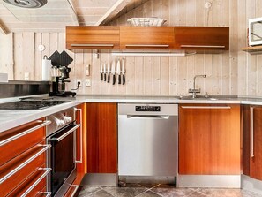 Una cocina moderna con armarios de madera, electrodomésticos de acero inoxidable y lavavajillas integrado.