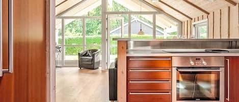 A modern kitchen with a large island, stainless steel appliances, and a view of the outdoors.