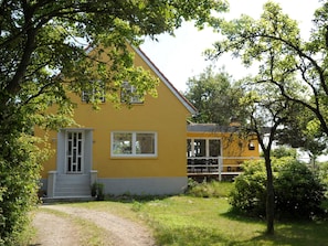 A yellow building with a white door and windows, surrounded by greenery and a clear sky. - 4 Star Holiday Home in Romo (Rømø)