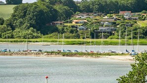 Een kustgebied met een jachthaven, huizen op een heuvel en een heldere lucht.