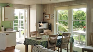 A compact kitchen with a dining area, a microwave, and a table with chairs.