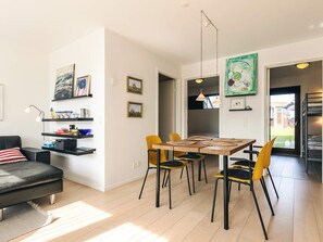 A modern living space with a dining area, a sofa, and artwork on the walls. - 4 Person Holiday Home in Bogense-by Traum (Bogense)