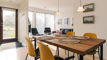 A dining area with a wooden table, yellow chairs, and woven placemats.