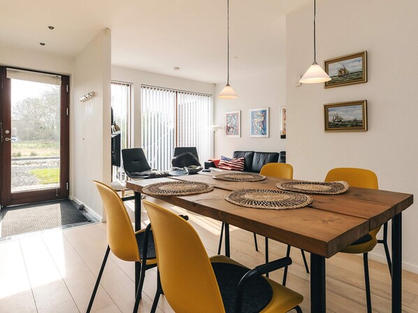 A dining area with a wooden table, yellow chairs, and woven placemats.