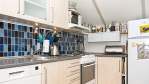 A compact kitchen with white cabinets, a built-in oven, and a microwave.
