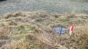 A grassy area with a manhole cover and a red and white sign. - 5 Star Holiday Home in Blokhus (Blokhus)