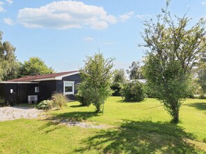 A residential property with a house, a lawn, and trees. - 7 Person Holiday Home in Hals (Hals)