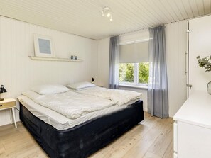 A bedroom with a bed, bedside tables, a window with curtains, and a wall-mounted shelf. - 7 Person Holiday Home in Hals (Hals)