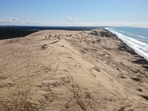 A sandy beach with a view of the ocean and distant hills. - 5 Star Holiday Home in Lokken (Lokken)
