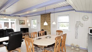A dining area with a round table, wooden chairs, and pendant lighting. - 6 Person Holiday Home in Lokken (Lokken)